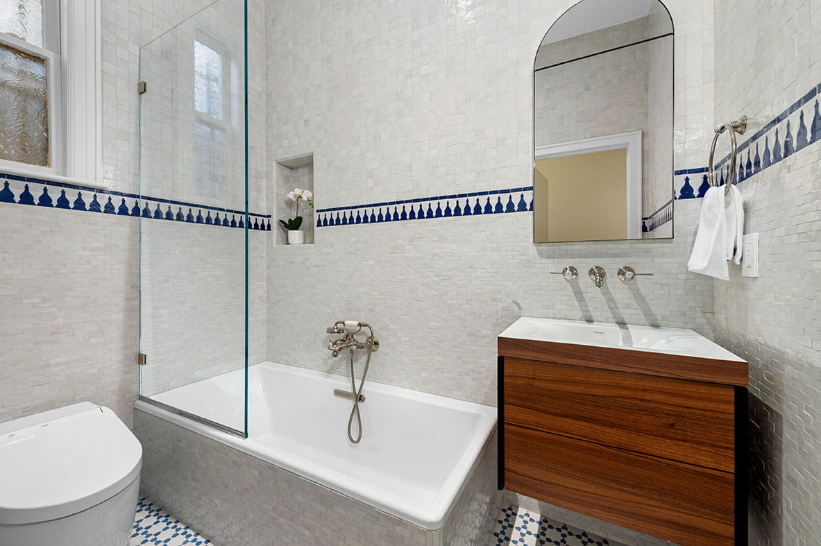 Tiled soaking tub and maroocan wall tiles with integrated wall niche for a convenient storage near the bathtub.
